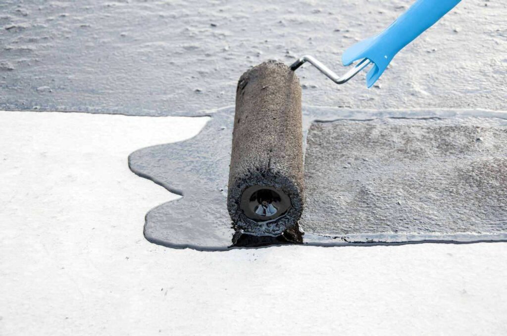 liquid based waterproofing material being applied with a paint roller